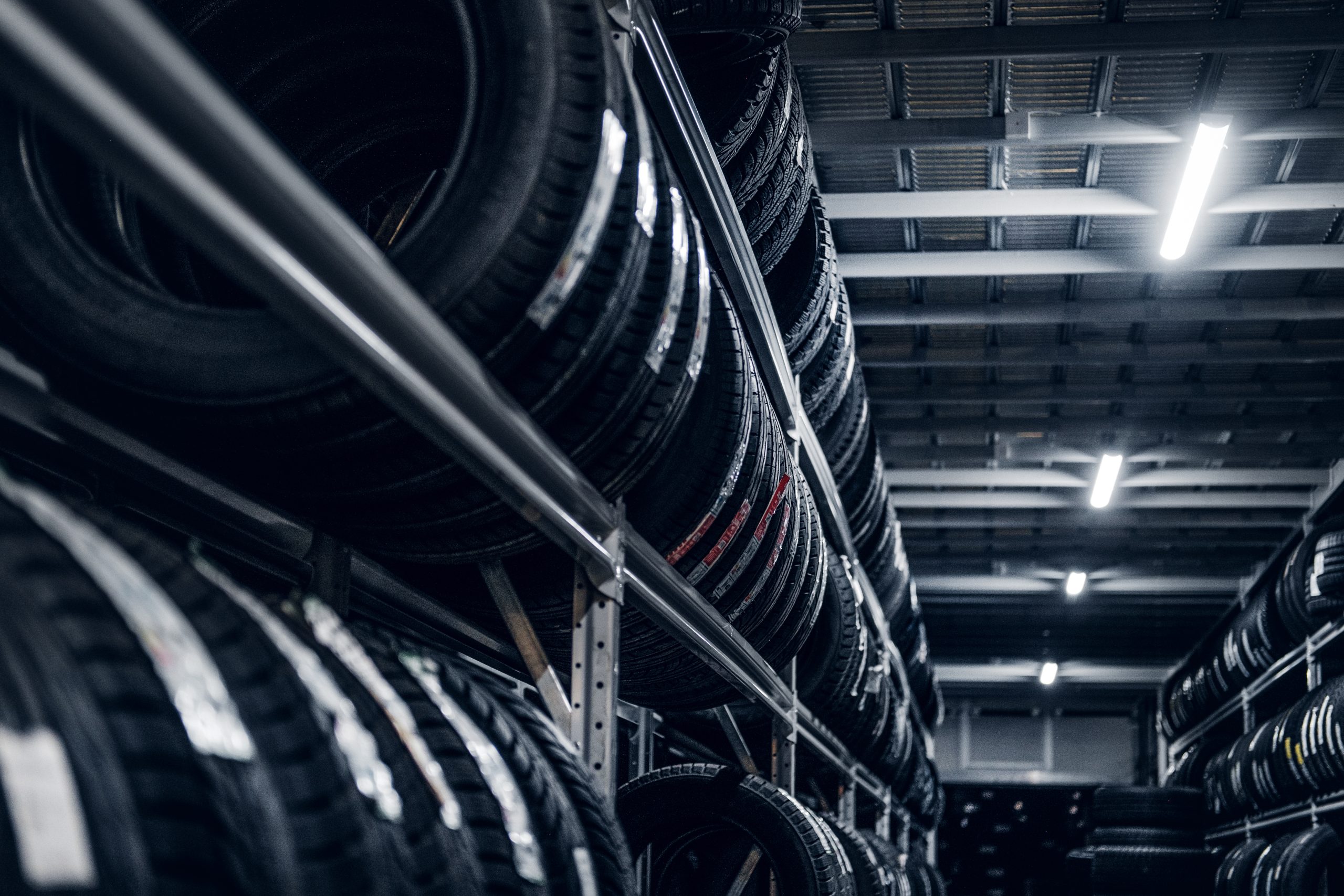 Dark storage full or big variety of new tyres at busy warehouse.